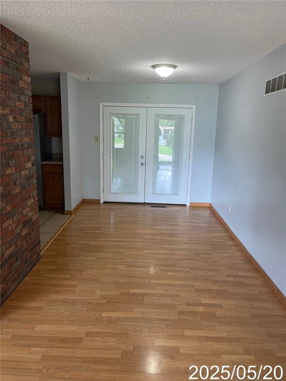 404 Glen Echo Dr, De Soto, MO 63020 - spare room with light wood-style floors, a textured ceiling, and baseboards