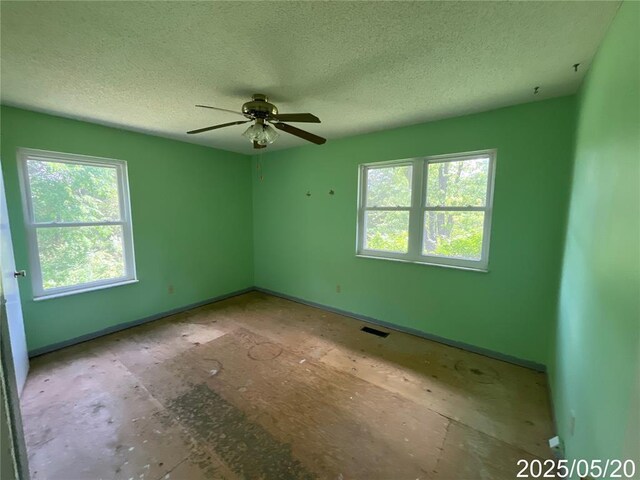 404 Glen Echo Dr, De Soto, MO 63020 - spare room featuring healthy amount of natural light, a textured ceiling, ceiling fan, and baseboards
