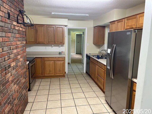 404 Glen Echo Dr, De Soto, MO 63020 - kitchen with appliances with stainless steel finishes, brick wall, a textured ceiling, light countertops, and light tile patterned floors