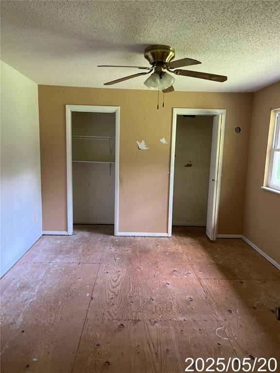 404 Glen Echo Dr, De Soto, MO 63020 - unfurnished bedroom with a textured ceiling, ceiling fan, and baseboards