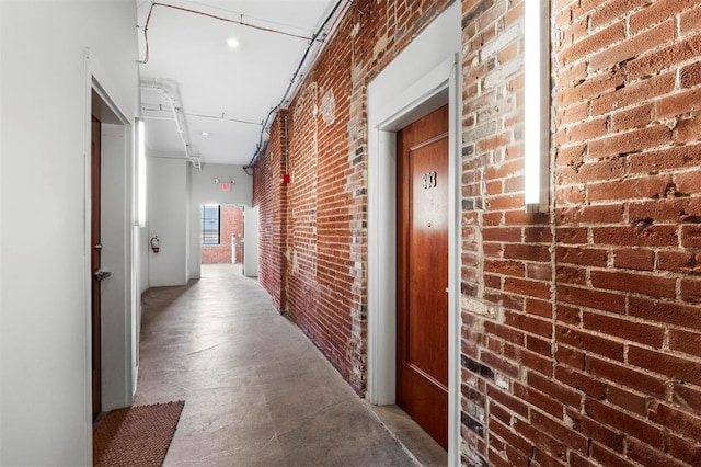 1720 Chouteau Ave Unit 303, Saint Louis, MO 63103 - hallway featuring brick wall and concrete flooring