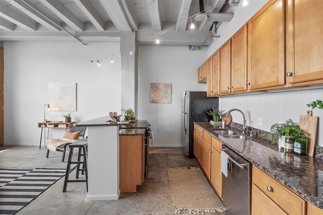 1720 Chouteau Ave Unit 303, Saint Louis, MO 63103 - kitchen featuring stainless steel appliances, a sink, a kitchen bar, beamed ceiling, and dark stone countertops