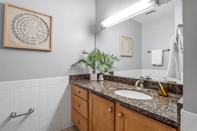 1720 Chouteau Ave Unit 303, Saint Louis, MO 63103 - bathroom with vanity, tile walls, and a wainscoted wall