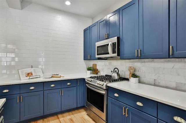 4412 Chouteau, Saint Louis, MO 63110 - kitchen with stainless steel gas range, white microwave, blue cabinetry, light countertops, and recessed lighting