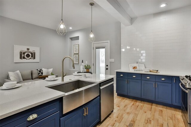 4412 Chouteau, Saint Louis, MO 63110 - kitchen featuring blue cabinetry, a sink, appliances with stainless steel finishes, light countertops, and light wood-style floors