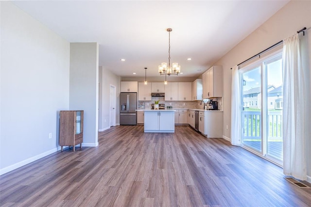 1051 Miremont Dr, Manchester, MO 63011 - kitchen featuring appliances with stainless steel finishes, under cabinet range hood, a chandelier, light wood-style flooring, and a sink