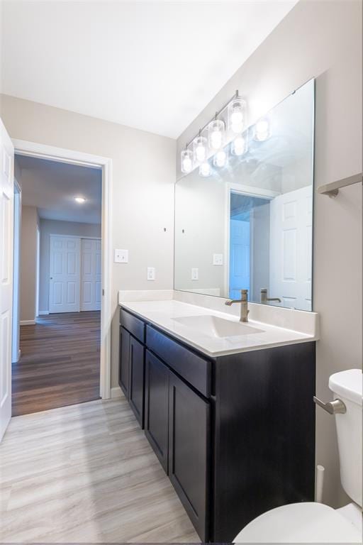1051 Miremont Dr, Manchester, MO 63011 - half bathroom with vanity, wood finished floors, toilet, and baseboards