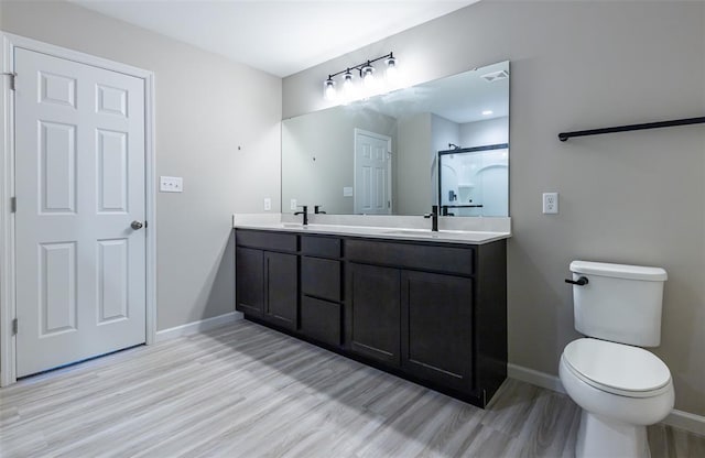 1051 Miremont Dr, Manchester, MO 63011 - bathroom featuring wood finished floors, baseboards, double vanity, and toilet