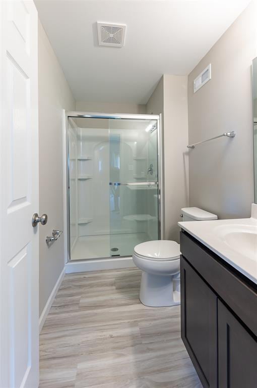 1051 Miremont Dr, Manchester, MO 63011 - full bathroom with vanity, toilet, a stall shower, and wood finished floors
