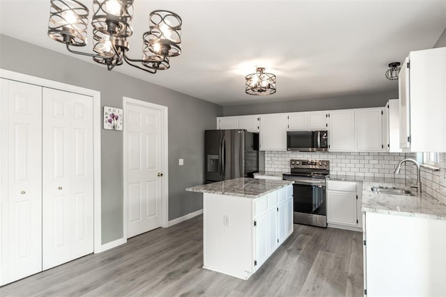 326 Merrimac Downs, Saint Peters, MO 63376 - kitchen with stainless steel appliances, a sink, light stone counters, tasteful backsplash, and a chandelier
