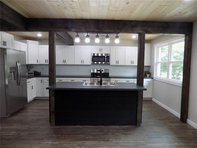 633 E Eldon St, St James, MO 65559 - kitchen with stainless steel appliances, a sink, baseboards, dark countertops, and dark wood finished floors