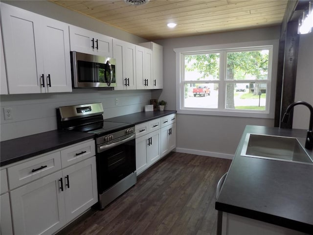 633 E Eldon St, St James, MO 65559 - kitchen featuring stainless steel appliances, wood ceiling, a sink, dark countertops, and dark wood-style floors
