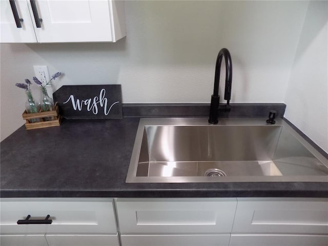 633 E Eldon St, St James, MO 65559 - kitchen view of a sink, dark countertops, and white cabinetry