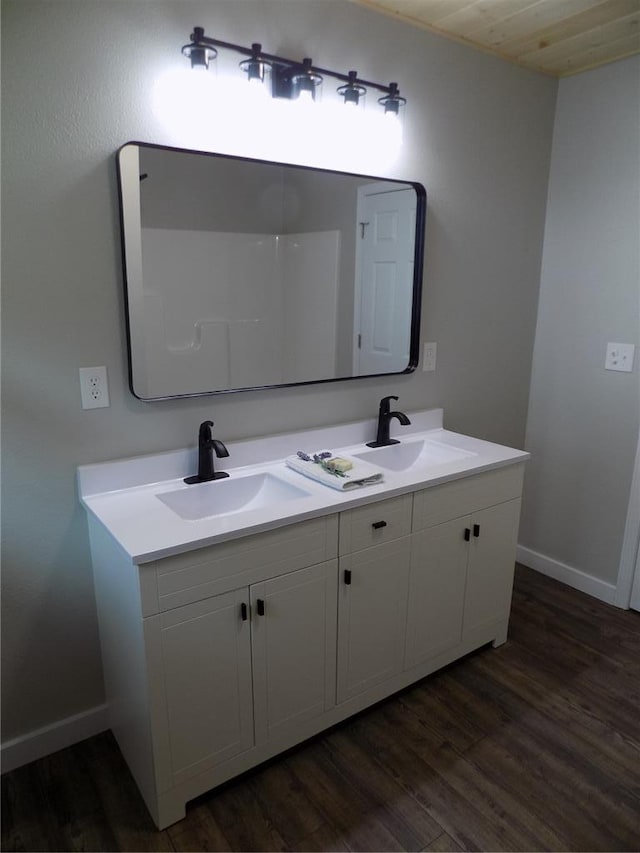 633 E Eldon St, St James, MO 65559 - bathroom featuring double vanity, baseboards, and wood finished floors