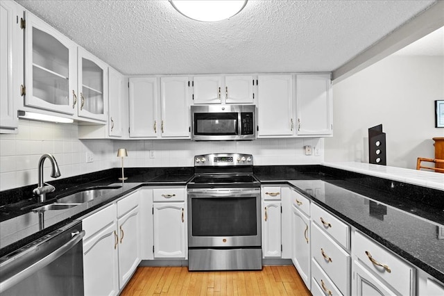 537 Colebrook Dr Unit C, Webster Groves, MO 63119 - kitchen with appliances with stainless steel finishes, a sink, white cabinets, a textured ceiling, and dark stone countertops
