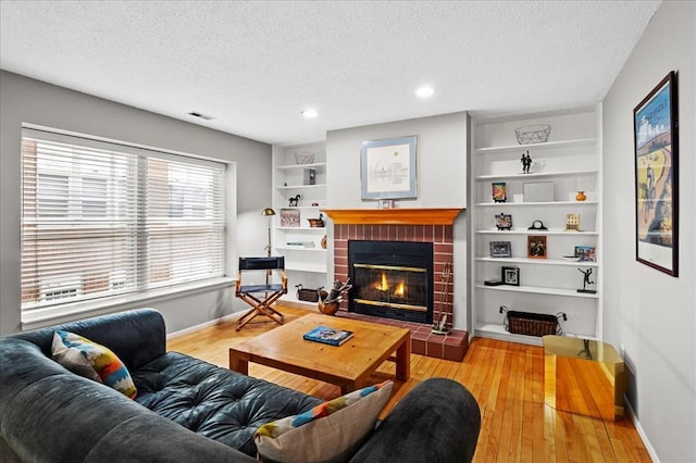 537 Colebrook Dr Unit C, Webster Groves, MO 63119 - living area with a textured ceiling, a fireplace, built in shelves, baseboards, and wood finished floors