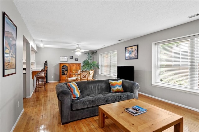 537 Colebrook Dr Unit C, Webster Groves, MO 63119 - living room with light wood-style flooring, a textured ceiling, a ceiling fan, and baseboards