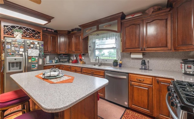 17130 State Route F, St James, MO 65559 - kitchen featuring appliances with stainless steel finishes, a sink, a kitchen breakfast bar, light countertops, and a center island