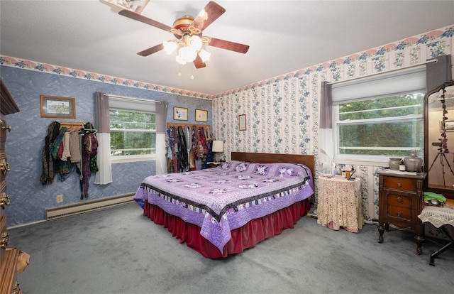 17130 State Route F, St James, MO 65559 - carpeted bedroom featuring a baseboard heating unit, wallpapered walls, multiple windows, and a ceiling fan