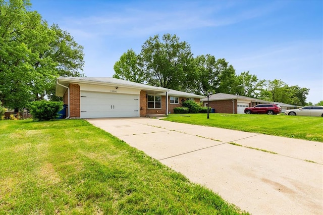 11550 Rock Hampton Dr, Hazelwood, MO 63138 - view of front of house with brick siding, concrete driveway, a garage, and a front lawn