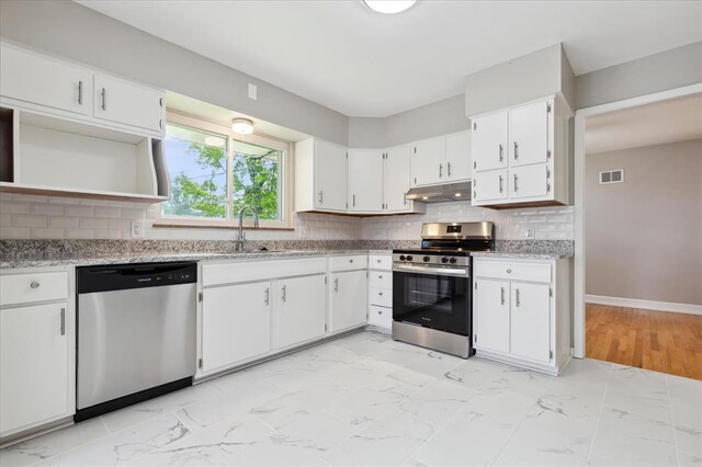 11550 Rock Hampton Dr, Hazelwood, MO 63138 - kitchen featuring stainless steel appliances, under cabinet range hood, a sink, light marble finish floors, and white cabinets