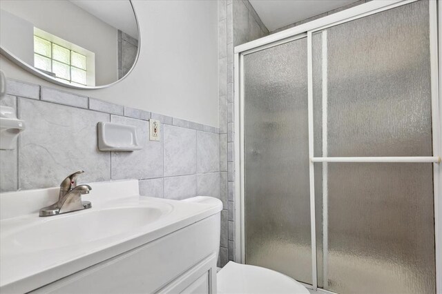 11550 Rock Hampton Dr, Hazelwood, MO 63138 - bathroom featuring a shower stall, vanity, tile walls, and toilet
