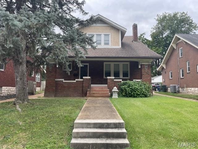 3670 Loughborough Ave, Saint Louis, MO 63116 - view of front of property with a porch, a chimney, a front yard, and brick siding
