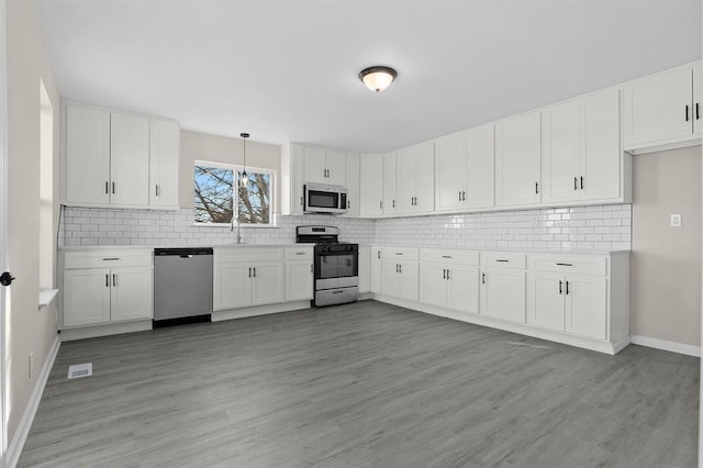 7097 State Route 3, Evansville, IL 62242 - kitchen with appliances with stainless steel finishes, backsplash, light countertops, and baseboards
