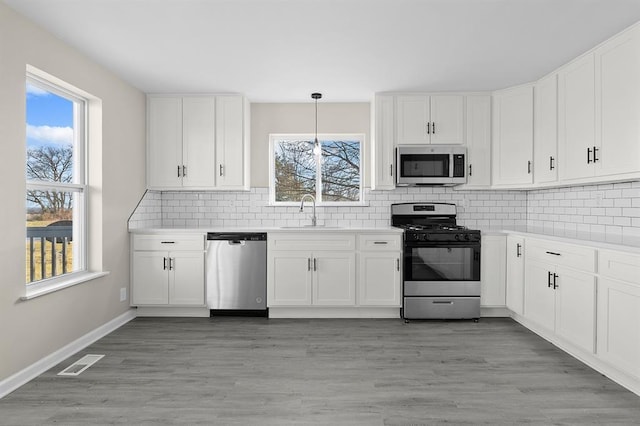 7097 State Route 3, Evansville, IL 62242 - kitchen featuring stainless steel appliances, a sink, white cabinets, and decorative backsplash