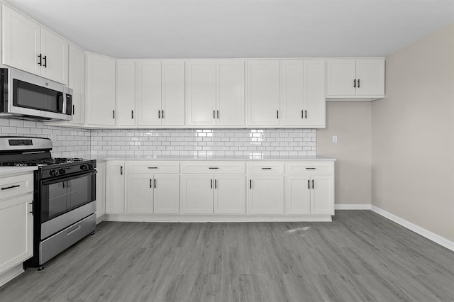 7097 State Route 3, Evansville, IL 62242 - kitchen featuring appliances with stainless steel finishes, baseboards, light countertops, and light wood-style flooring