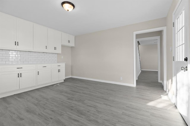 7097 State Route 3, Evansville, IL 62242 - kitchen with white cabinets, backsplash, light wood-style floors, and baseboards