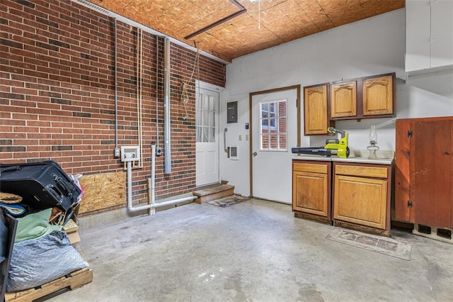 114 Fairlane Dr, Ironton, MO 63650 - kitchen with unfinished concrete flooring, an ornate ceiling, brick wall, light countertops, and brown cabinets
