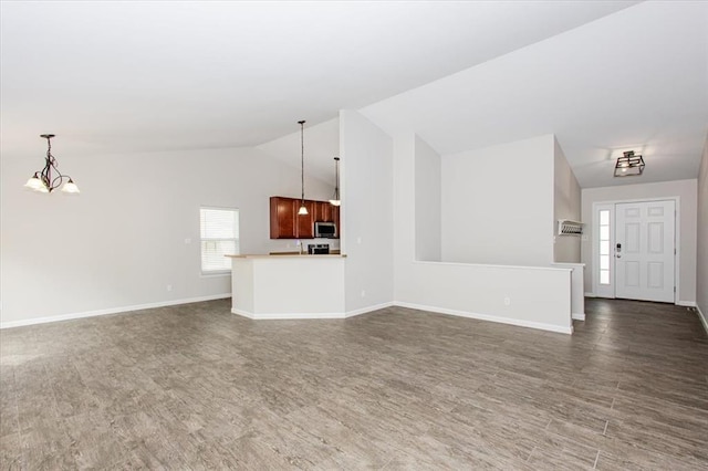 614 Palisades View Dr, Eureka, MO 63025 - unfurnished living room with a chandelier, lofted ceiling, wood finished floors, and baseboards