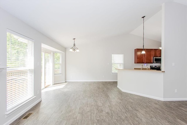 614 Palisades View Dr, Eureka, MO 63025 - unfurnished living room featuring a chandelier, lofted ceiling, light wood-style flooring, and baseboards