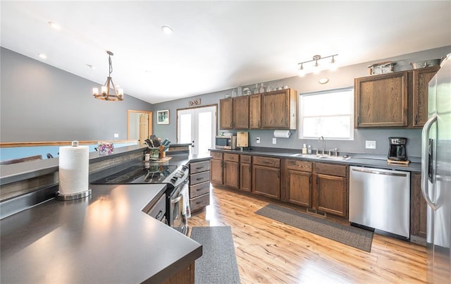 19285 State Route Ee, St James, MO 65559 - kitchen with stainless steel appliances, a sink, dark countertops, vaulted ceiling, and light wood-style floors