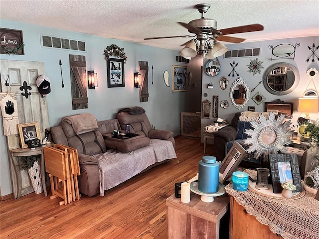 12241 Pipeline Rd, Bourbon, MO 65441 - living room featuring a ceiling fan, wood finished floors, and a textured ceiling