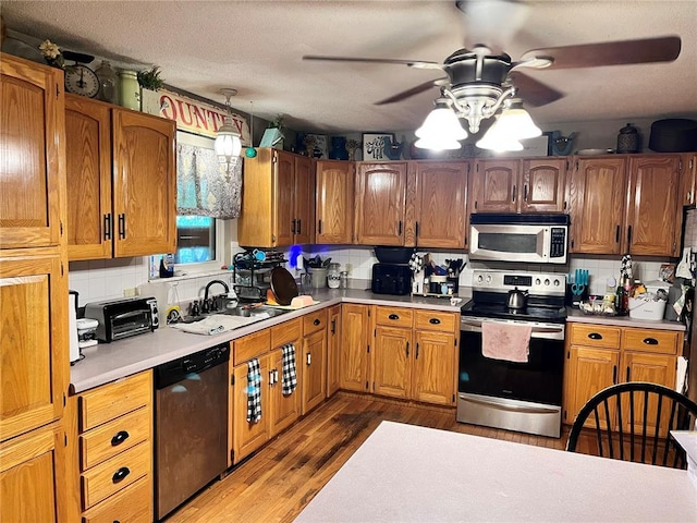 12241 Pipeline Rd, Bourbon, MO 65441 - kitchen featuring stainless steel appliances, ceiling fan, a sink, light countertops, and backsplash
