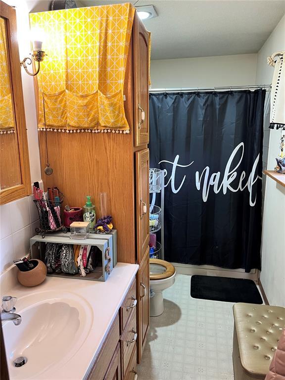 12241 Pipeline Rd, Bourbon, MO 65441 - bathroom with vanity, toilet, and curtained shower