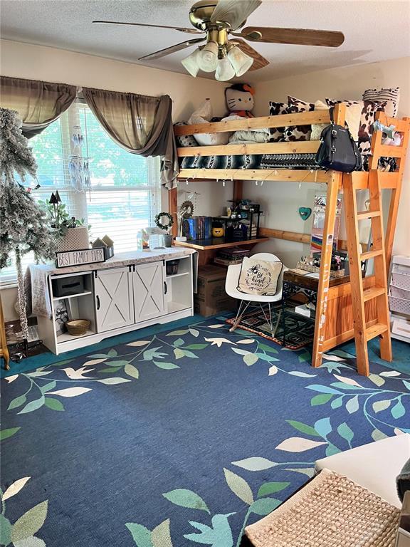 12241 Pipeline Rd, Bourbon, MO 65441 - carpeted bedroom featuring a textured ceiling and a ceiling fan