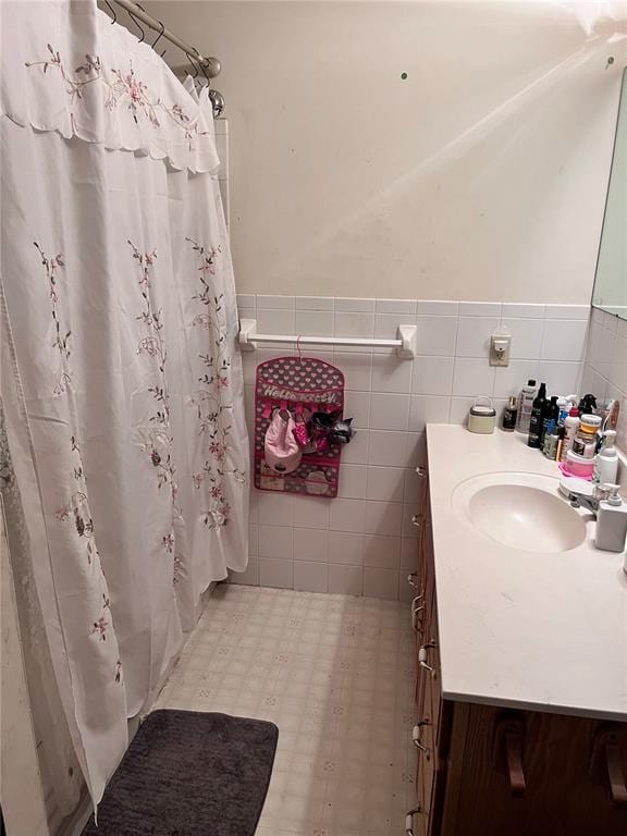 12241 Pipeline Rd, Bourbon, MO 65441 - bathroom with vanity, a shower with curtain, wainscoting, and tile walls