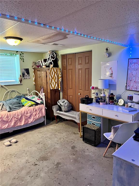 12241 Pipeline Rd, Bourbon, MO 65441 - bedroom featuring a paneled ceiling, concrete floors, and a closet