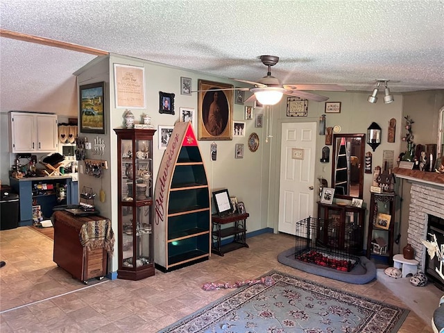12241 Pipeline Rd, Bourbon, MO 65441 - living area with ceiling fan, a textured ceiling, and a fireplace