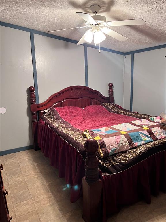 12241 Pipeline Rd, Bourbon, MO 65441 - bedroom with a textured ceiling, a ceiling fan, and light flooring