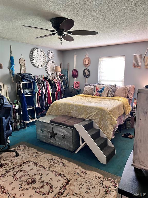 12241 Pipeline Rd, Bourbon, MO 65441 - carpeted bedroom with a textured ceiling and ceiling fan