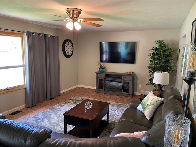 1018 S Spring St, Palmyra, MO 63461 - living area with baseboards, plenty of natural light, a ceiling fan, and wood finished floors