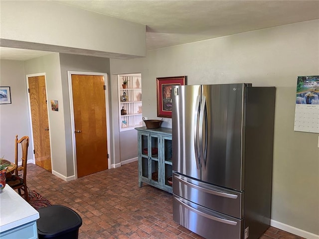 1018 S Spring St, Palmyra, MO 63461 - kitchen with freestanding refrigerator, brick patterned flooring, and baseboards