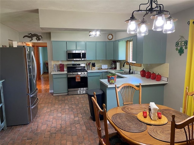 1018 S Spring St, Palmyra, MO 63461 - kitchen featuring appliances with stainless steel finishes, a sink, a peninsula, brick flooring, and light countertops