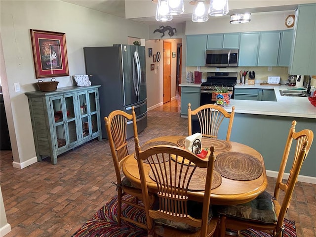 1018 S Spring St, Palmyra, MO 63461 - dining space with brick flooring, baseboards, and a chandelier