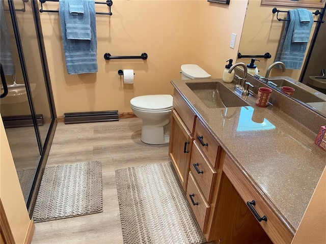 1018 S Spring St, Palmyra, MO 63461 - bathroom with vanity, toilet, a shower stall, and wood finished floors