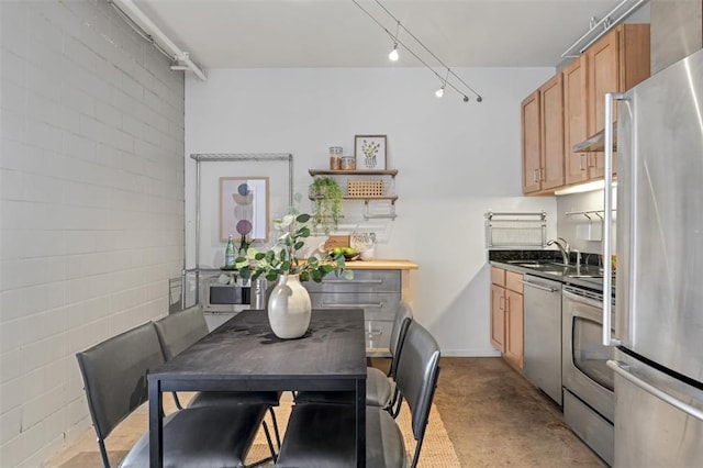 1720 Chouteau Ave Unit 110, Saint Louis, MO 63103 - kitchen with appliances with stainless steel finishes, track lighting, a sink, dark countertops, and open shelves